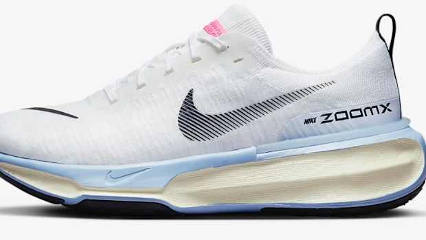 Side view of white and blue Nike shoe.